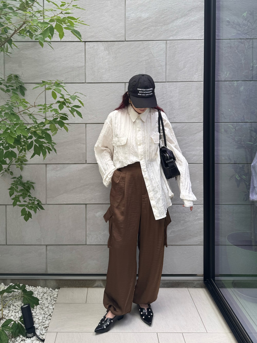 ブラウン系のその他パンツ、ブラック系のボストンバッグ、ブラック系のパンプスを着用したレディースの秋コーディネートの2枚目の写真