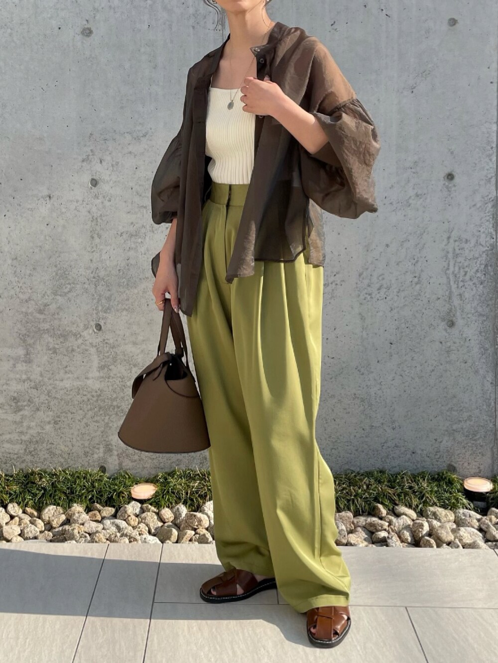 ブラウン系のシャツ/ブラウス、グリーン系のスラックス、ブラウン系のサンダルを着用したレディースの夏コーディネートの3枚目の写真