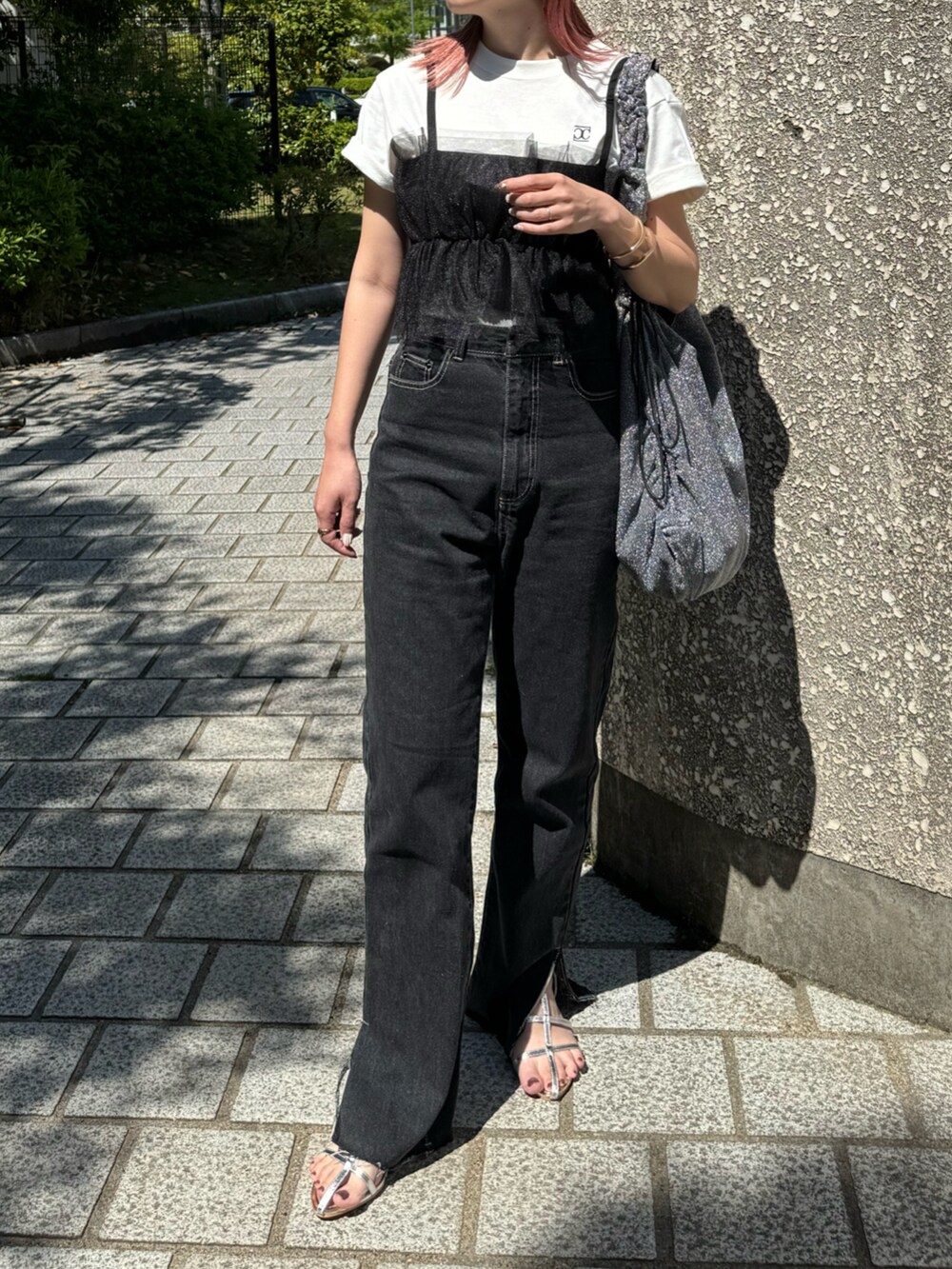 ホワイト系のTシャツ/カットソー、ブラック系のデニムパンツ、シルバー系のトートバッグを着用したレディースの春コーディネートの3枚目の写真