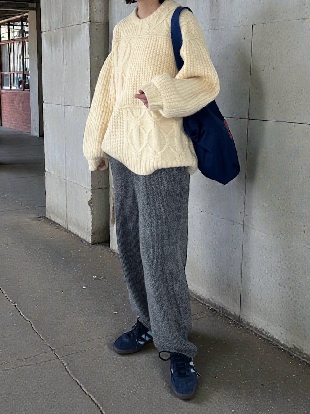 グレー系のその他パンツ、ブルー系のスニーカー、ホワイト系のニット/セーターを着用したレディースの冬コーディネートの2枚目の写真