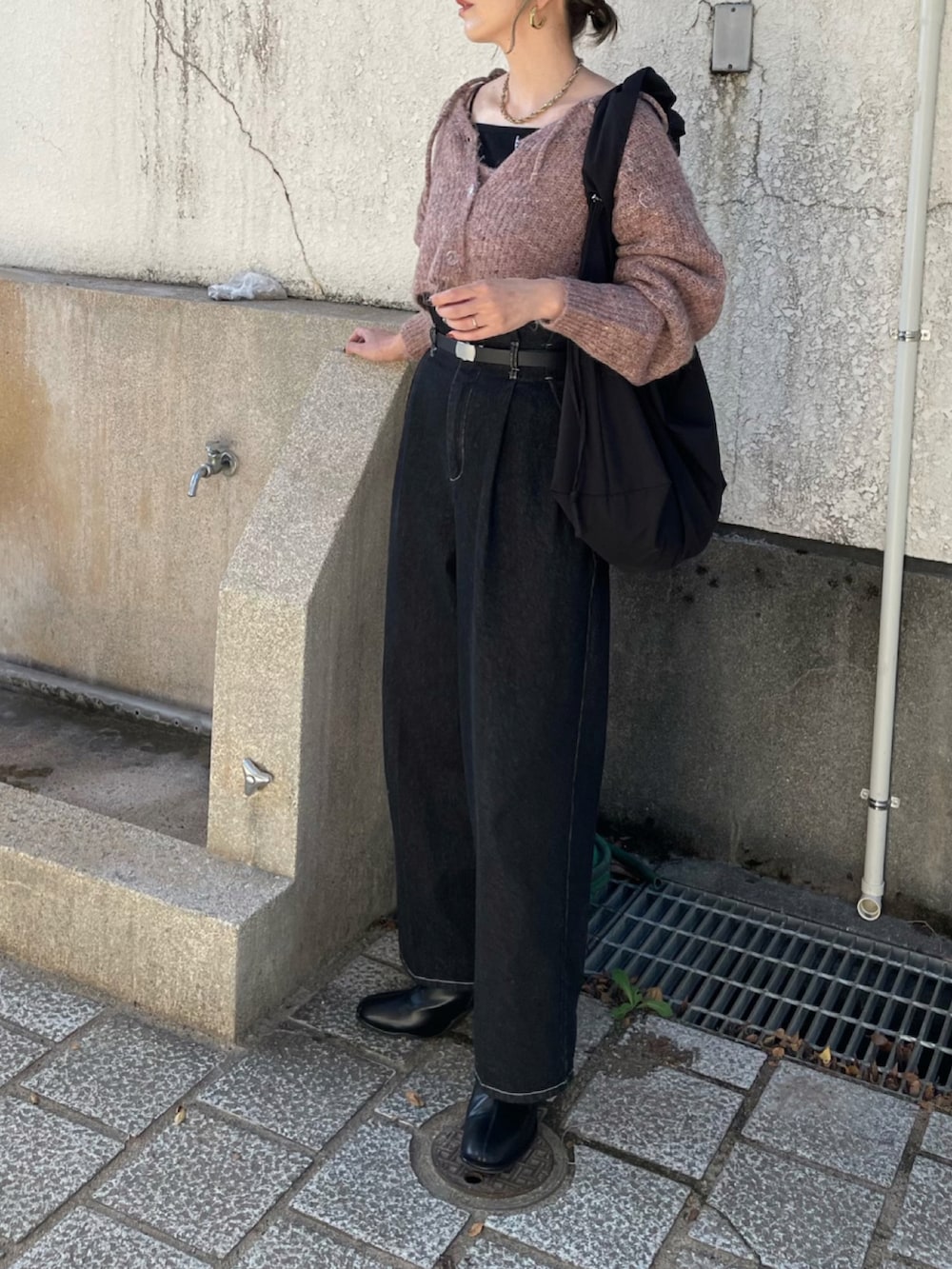 ピンク系のカーディガン/ボレロ、ブラック系のショルダーバッグ、ブラック系のデニムパンツを着用したレディースの秋コーディネートの3枚目の写真