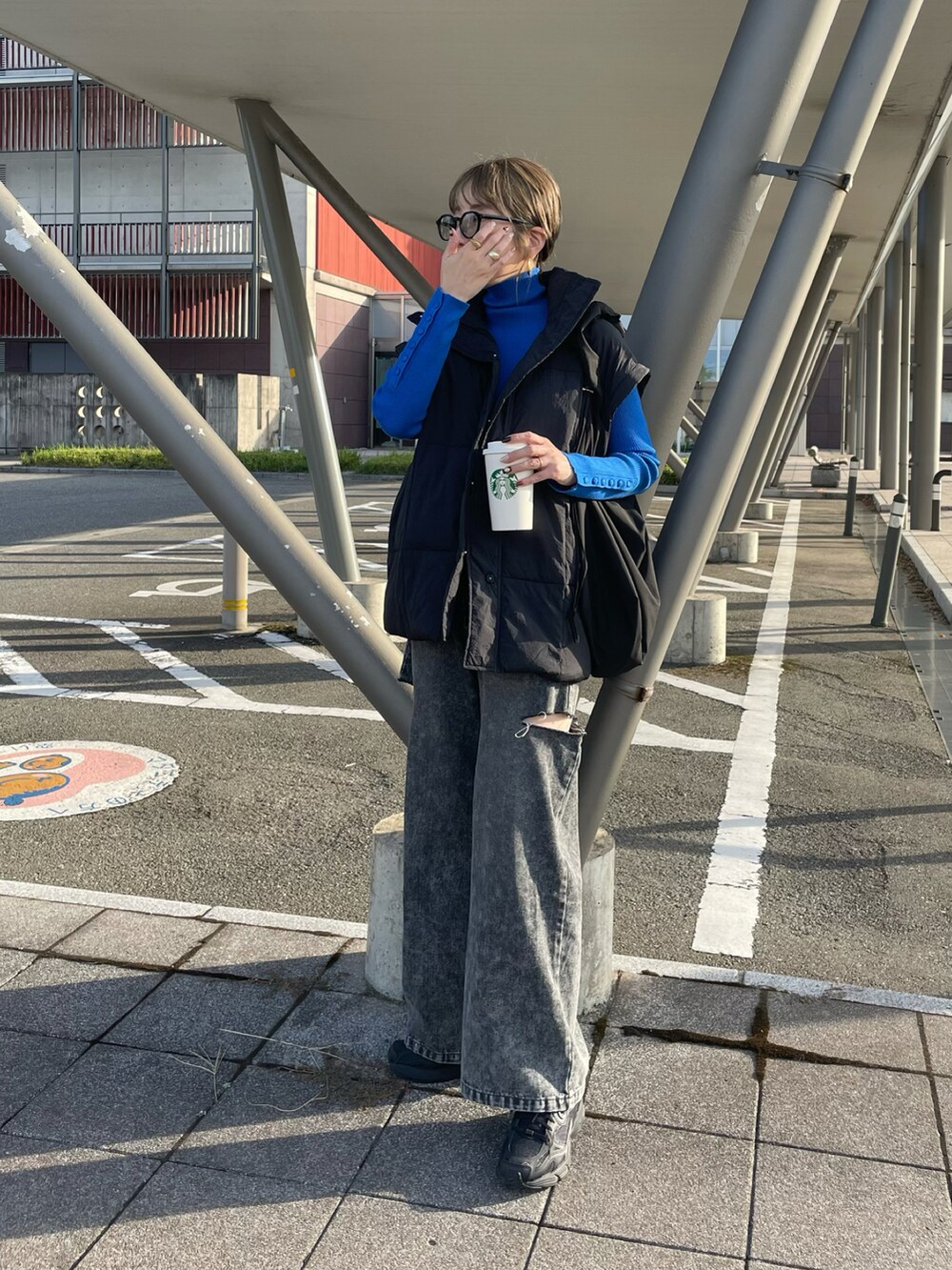 ブルー系のニット/セーター、ブラック系のデニムパンツ、ブラック系のスニーカーを着用したレディースの秋コーディネートの3枚目の写真