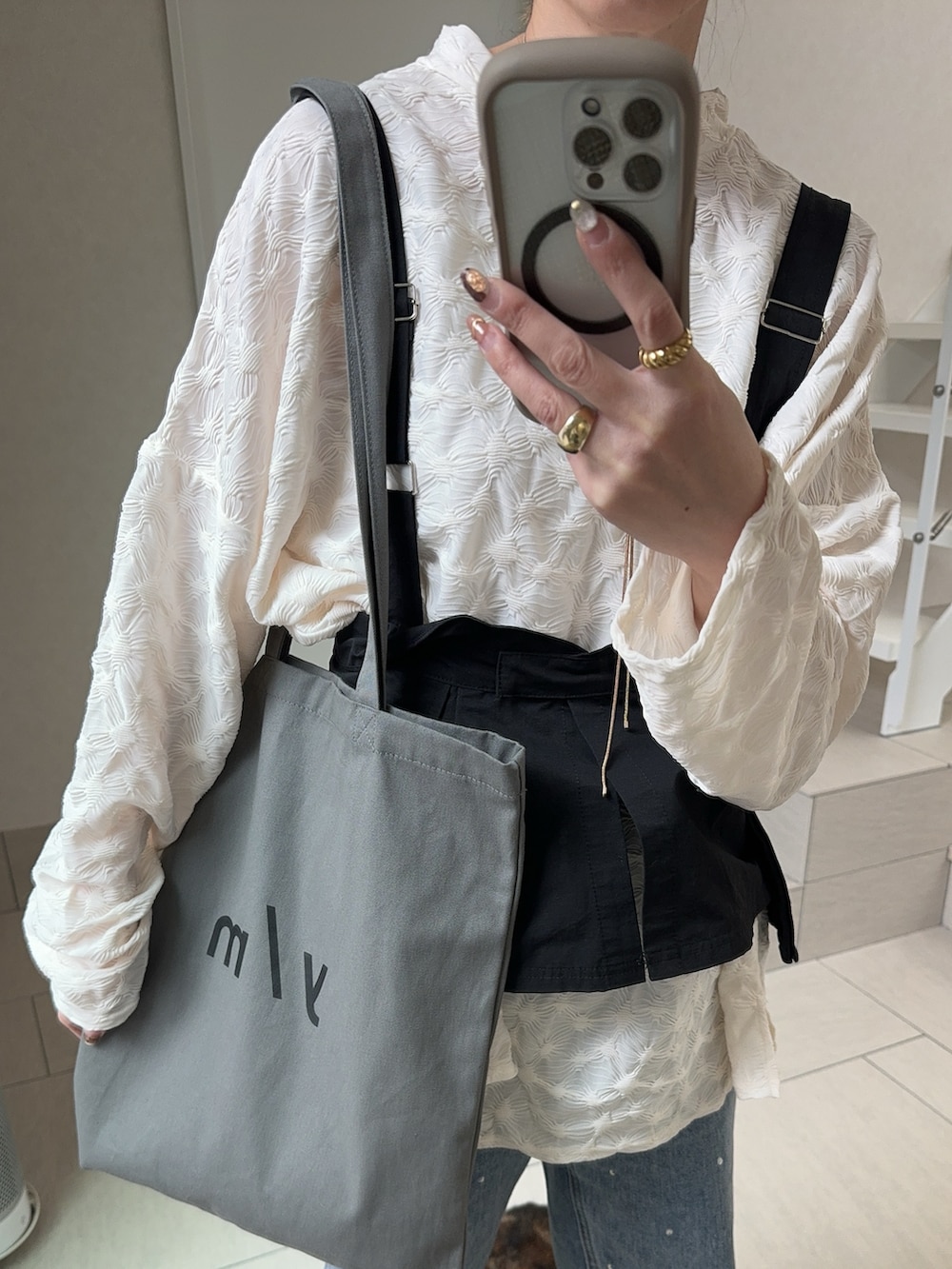 ホワイト系のTシャツ/カットソー、グレー系のトートバッグ、ブルー系のデニムパンツを着用したレディースの冬コーディネートの5枚目の写真