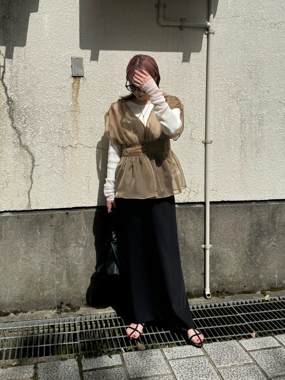 ベージュ系のTシャツ/カットソー、ブラック系のサンダル、ブラック系のスカートを着用したレディースの春コーディネートの5枚目の写真