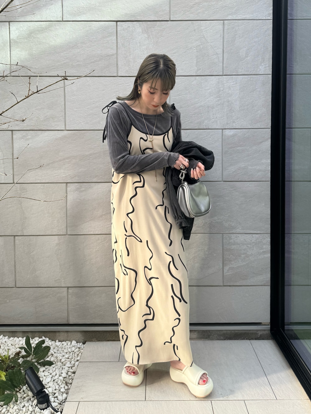 ホワイト系のワンピース、シルバー系のショルダーバッグ、グレー系のTシャツ/カットソーを着用したレディースの春コーディネートの2枚目の写真