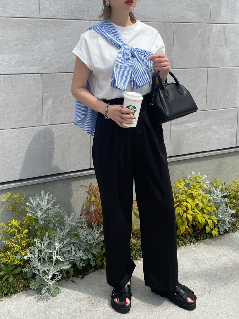 ブラック系のその他パンツ、ブラック系のサンダル、ブラック系のボストンバッグを着用したレディースの春コーディネートの2枚目の写真