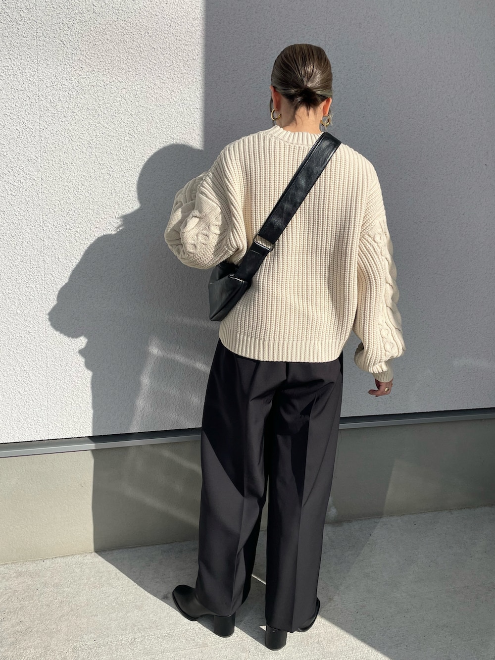 ホワイト系のニット/セーター、ブラック系のブーツ、ブラック系のその他パンツを着用したレディースの秋コーディネートの4枚目の写真