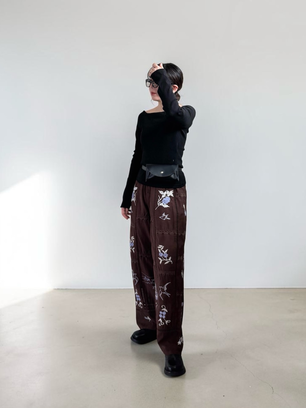 ブラック系のその他シューズ、ブラック系のボディバッグ/ウエストポーチ、ブラック系のTシャツ/カットソーを着用したレディースの春コーディネートの2枚目の写真