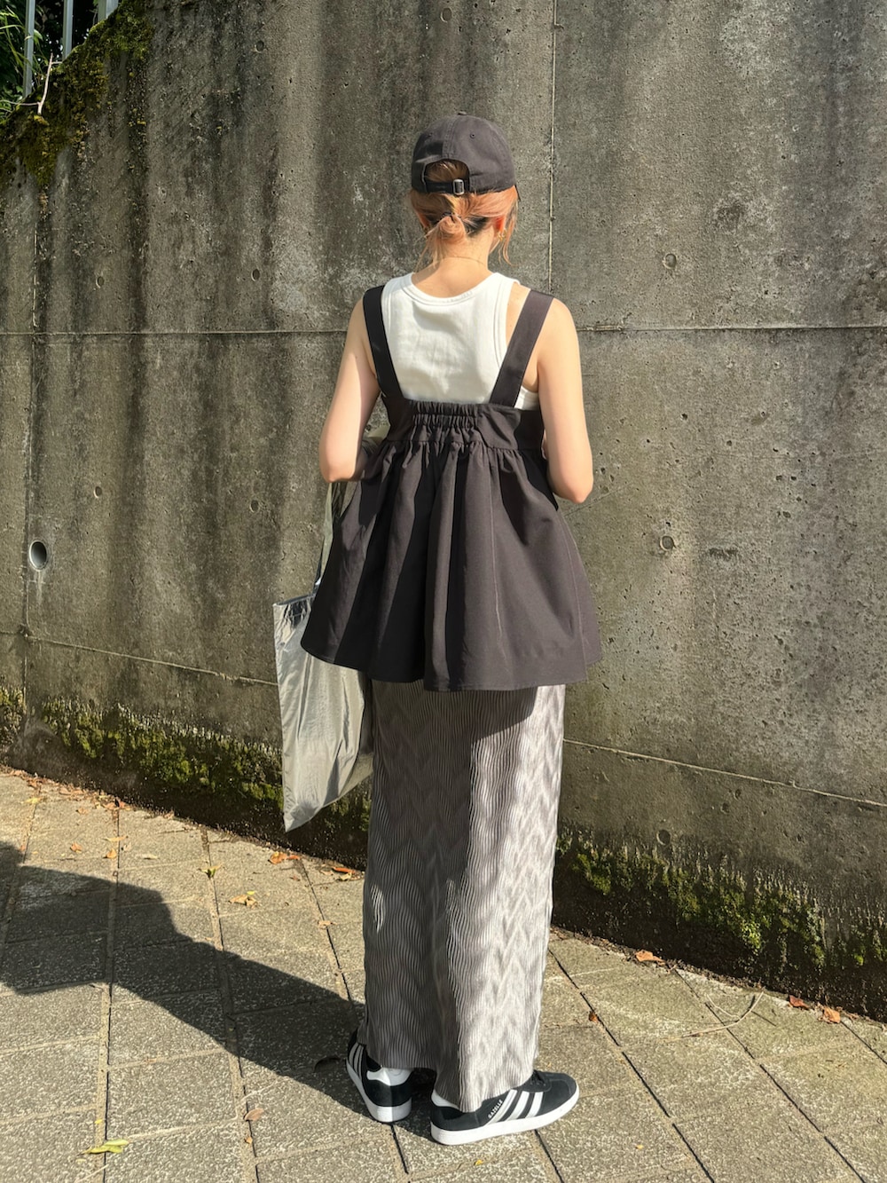 グレー系のスカート、ブラック系のその他トップス、シルバー系のトートバッグを着用したレディースの夏コーディネートの4枚目の写真