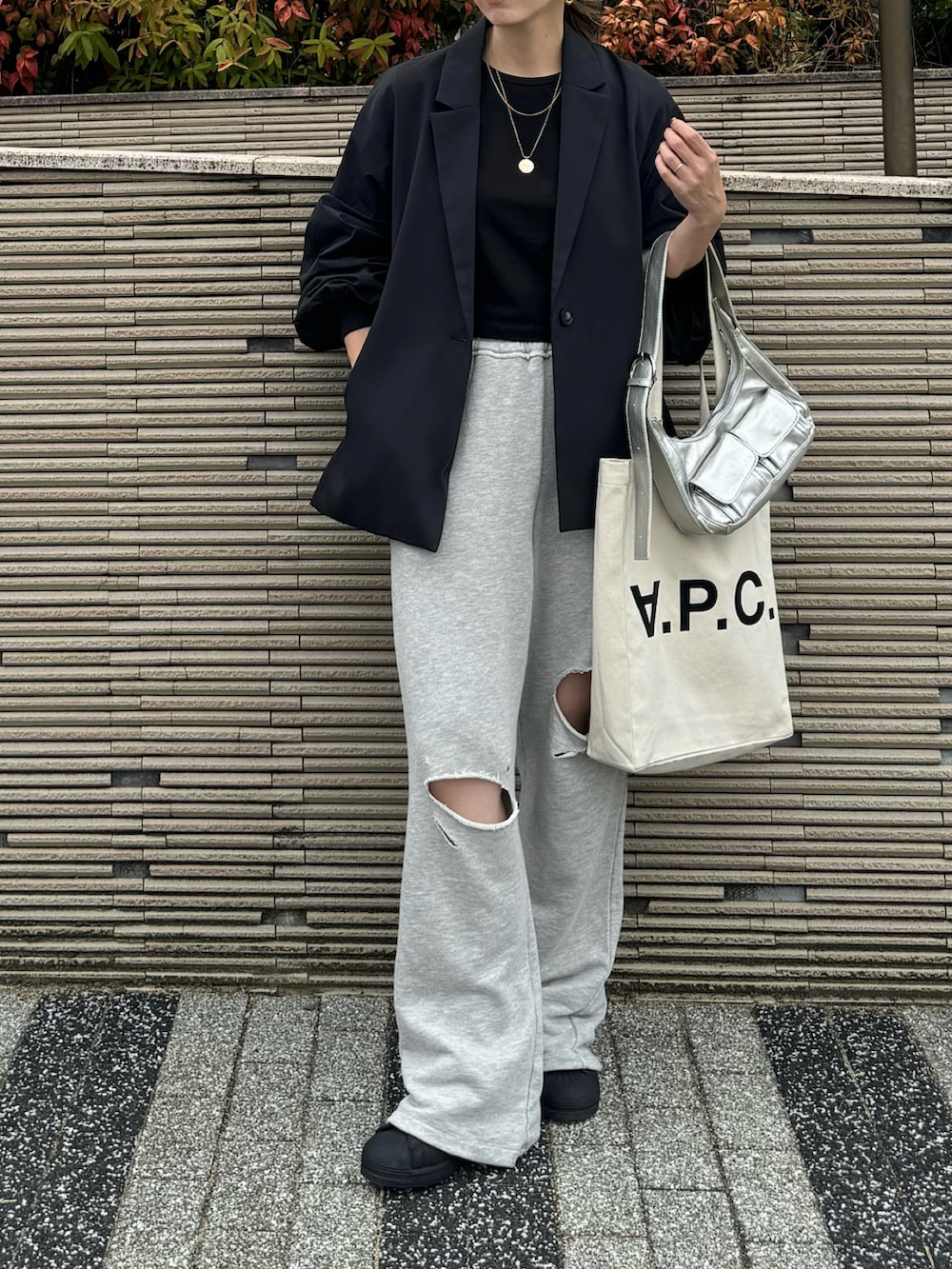 グレー系のスウェットパンツ、ブラック系のスニーカー、ホワイト系のトートバッグを着用したレディースの秋コーディネートの5枚目の写真