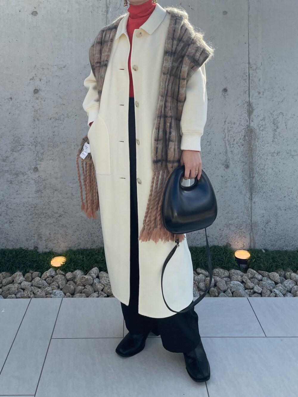 ホワイト系のステンカラーコート、ブラック系のその他パンツ、ブラック系のブーツを着用したレディースの秋コーディネートの2枚目の写真