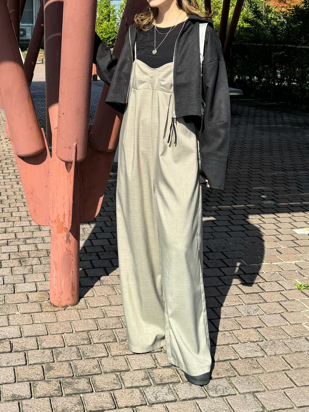 ブラック系のその他アウター、シルバー系のショルダーバッグ、ブラック系のTシャツ/カットソーを着用したレディースの秋コーディネートの2枚目の写真