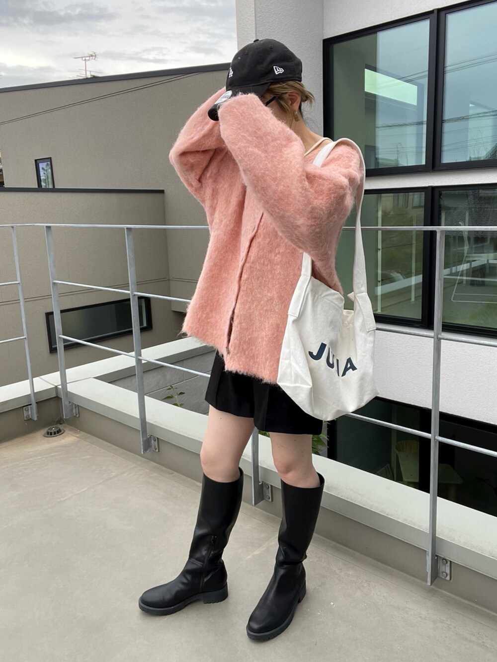 オレンジ系のニット/セーター、ブラック系のその他パンツ、ホワイト系のキャミソールを着用したレディースの秋コーディネートの2枚目の写真