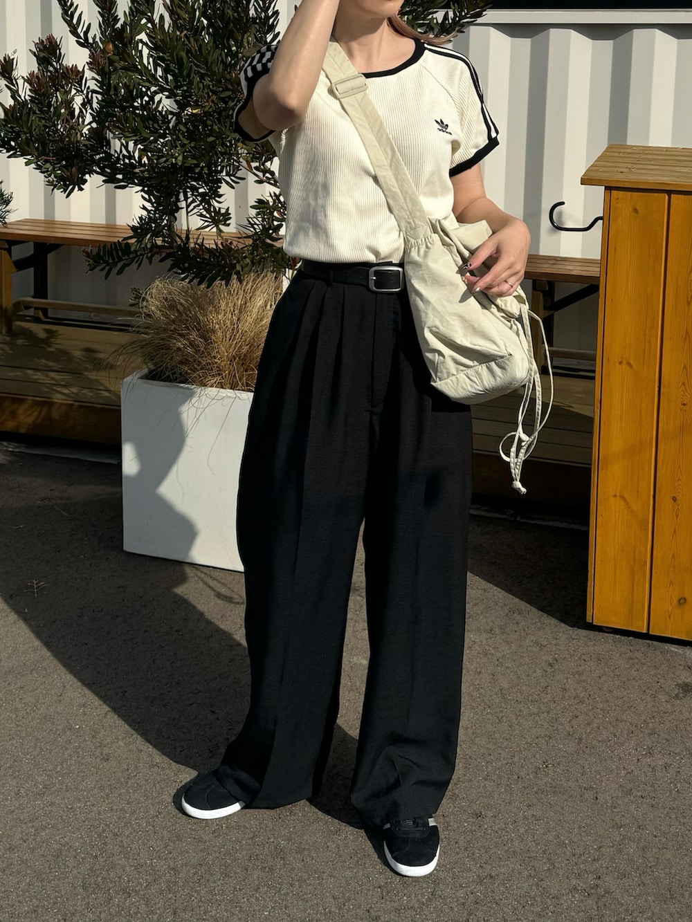 ブラック系のその他パンツ、ブラック系のスニーカー、ホワイト系のTシャツ/カットソーを着用したレディースの夏コーディネートの3枚目の写真