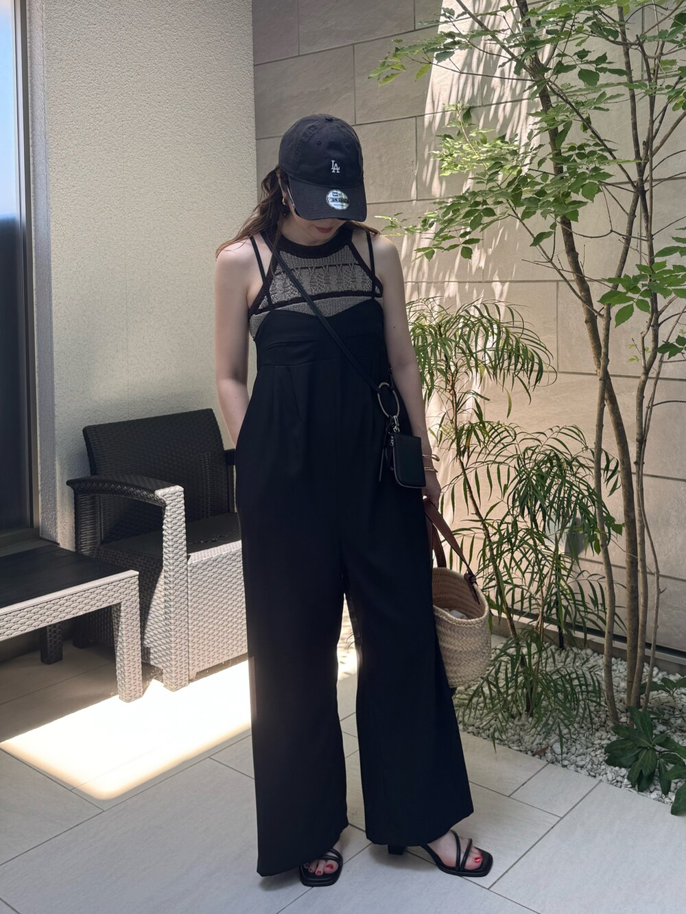 グリーン系のタンクトップ、ブラック系のサロペット/オーバーオール、ブラック系のサンダルを着用したレディースの夏コーディネートの3枚目の写真