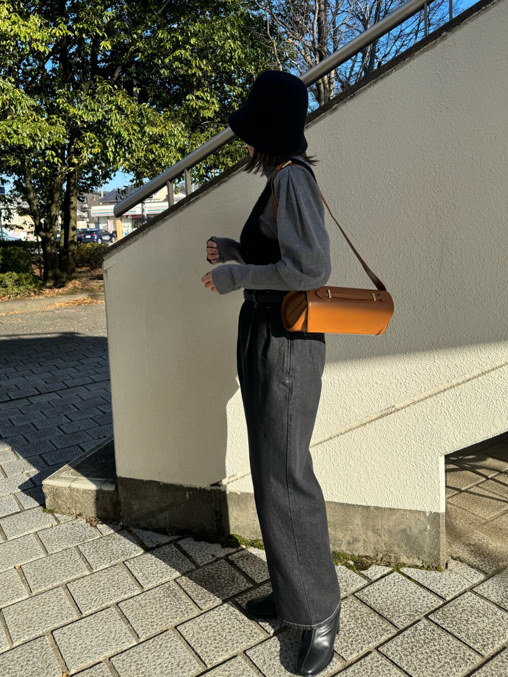 ブラック系のニット/セーター、ベージュ系のショルダーバッグ、グレー系のニット/セーターを着用したレディースの冬コーディネートの3枚目の写真