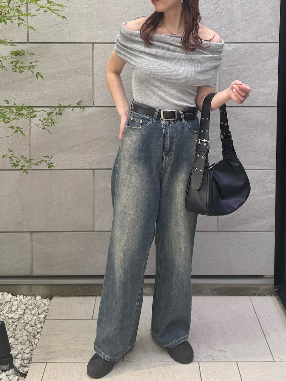 グレー系のニット/セーター、ブルー系のデニムパンツ、ブラック系のハンドバッグを着用したレディースの春コーディネートの3枚目の写真
