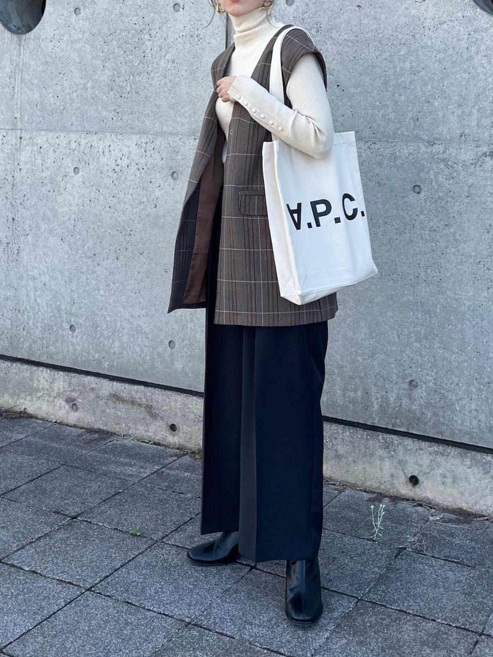 ホワイト系のニット/セーター、ホワイト系のトートバッグ、その他のベストを着用したレディースの冬コーディネートの3枚目の写真