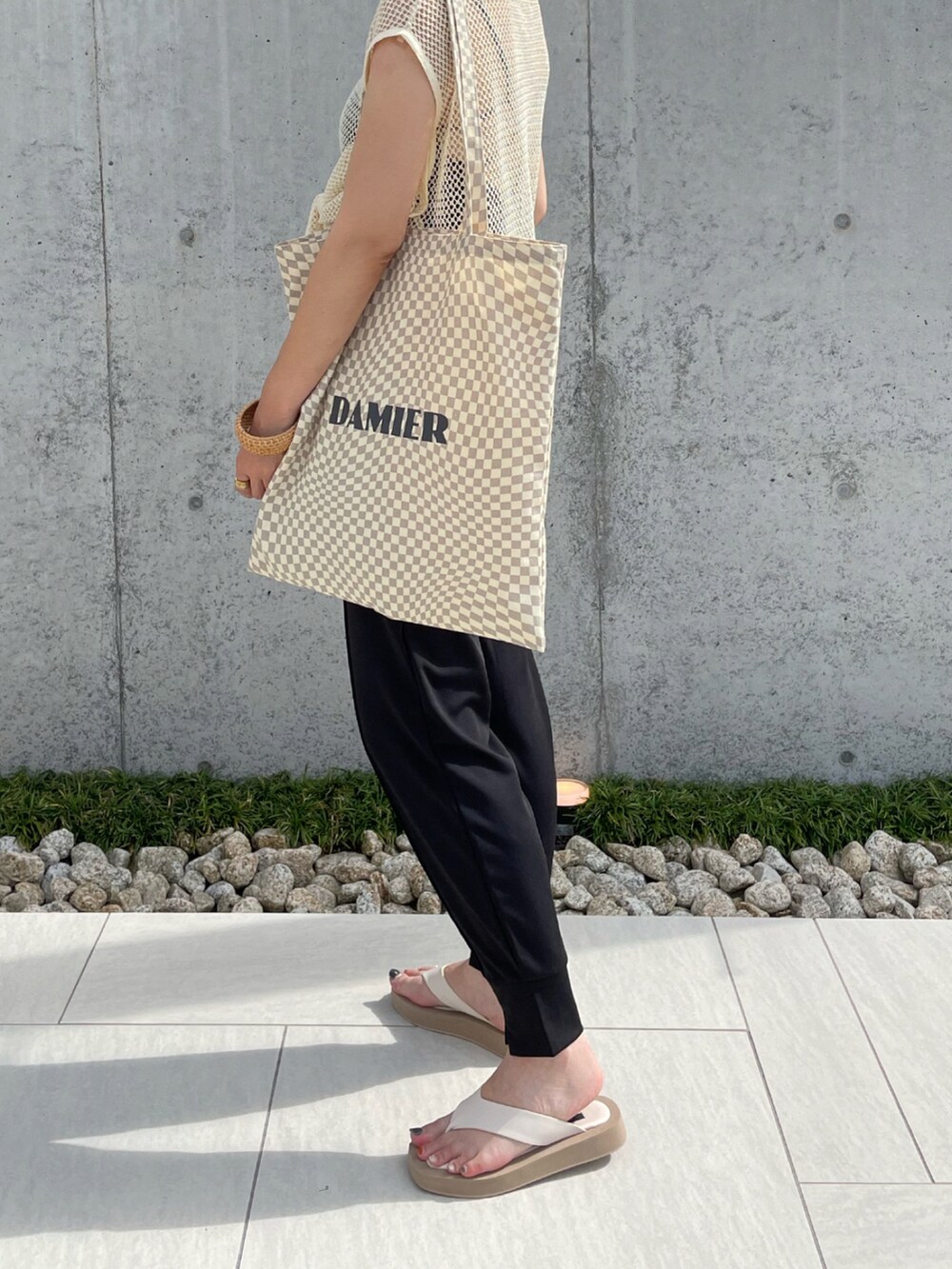 ブラック系のその他パンツ、ホワイト系のTシャツ/カットソー、ホワイト系のサンダルを着用したレディースの夏コーディネートの4枚目の写真