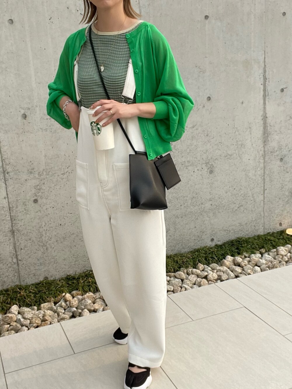 グリーン系のタンクトップ、グリーン系のカーディガン/ボレロ、ブラック系のショルダーバッグを着用したレディースの春コーディネートの2枚目の写真