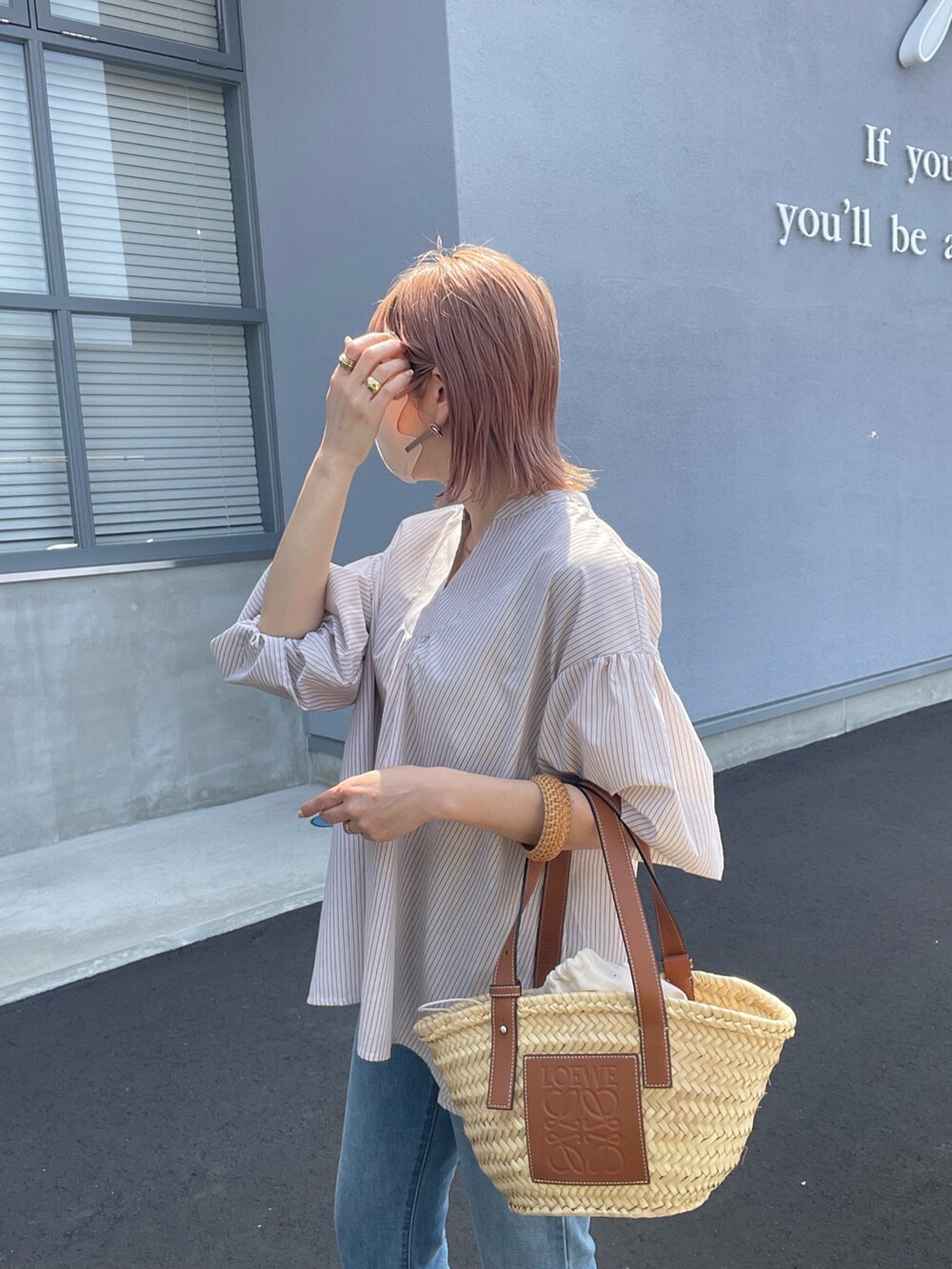 ベージュ系のシャツ/ブラウス、ブラウン系のトートバッグ、ブルー系のデニムパンツを着用したレディースの春コーディネートの4枚目の写真