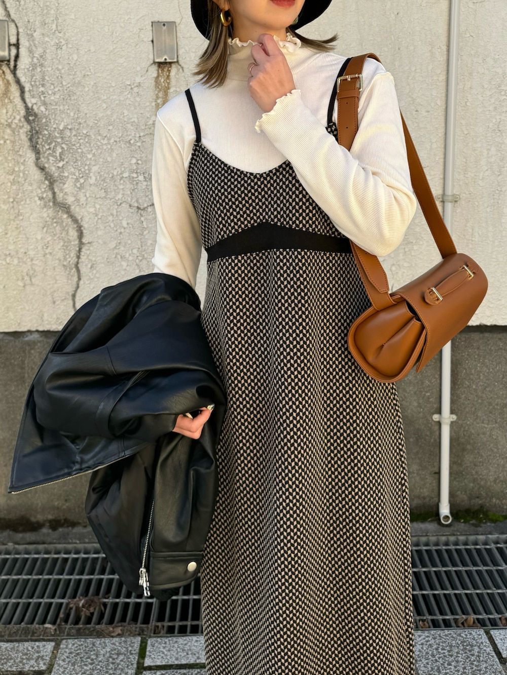 ホワイト系のTシャツ/カットソー、ブラック系のワンピース、ブラック系のライダースジャケットを着用したレディースの冬コーディネートの5枚目の写真