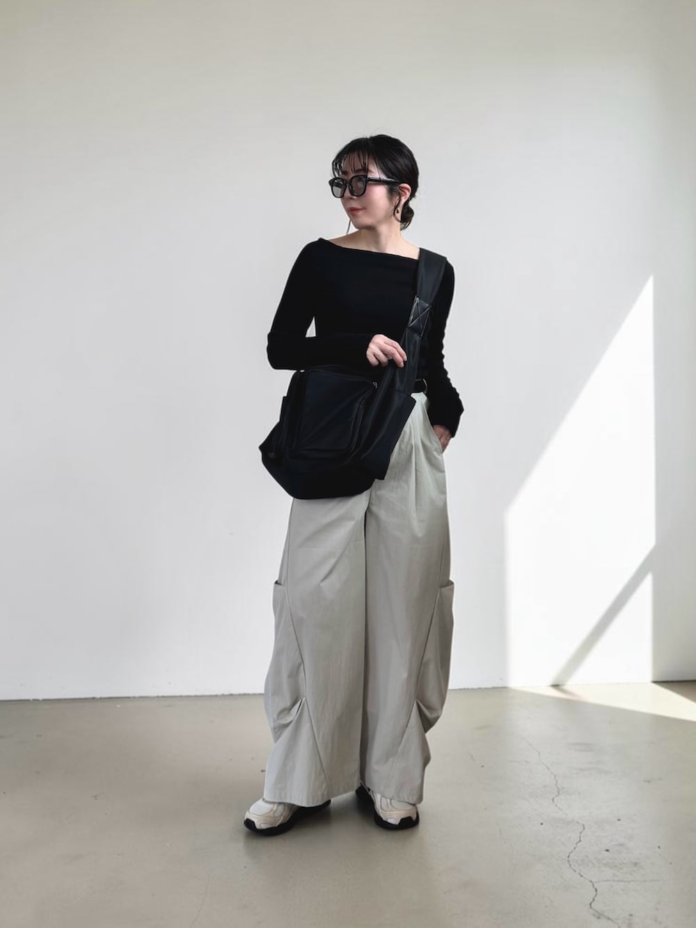 ブラック系のTシャツ/カットソー、グレー系のその他パンツ、ブラック系のショルダーバッグを着用したレディースの春コーディネートの3枚目の写真