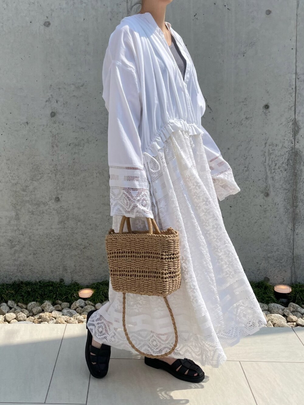 ホワイト系のワンピース、ブラック系のサンダルを着用したレディースの夏コーディネートの2枚目の写真