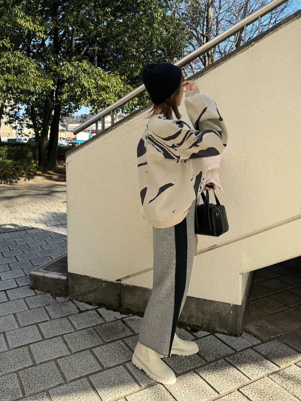 ホワイト系のブーツ、ホワイト系のその他アウター、グレー系のスカートを着用したレディースの冬コーディネートの5枚目の写真