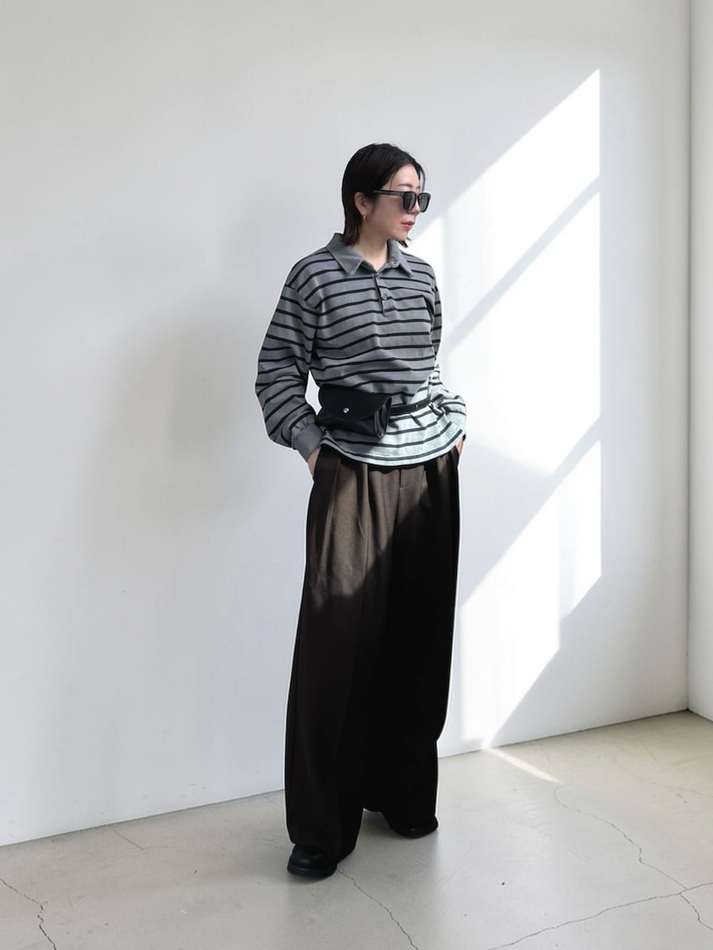 ブラウン系のその他パンツ、ブラック系のその他シューズ、グレー系のTシャツ/カットソーを着用したレディースの春コーディネートの2枚目の写真