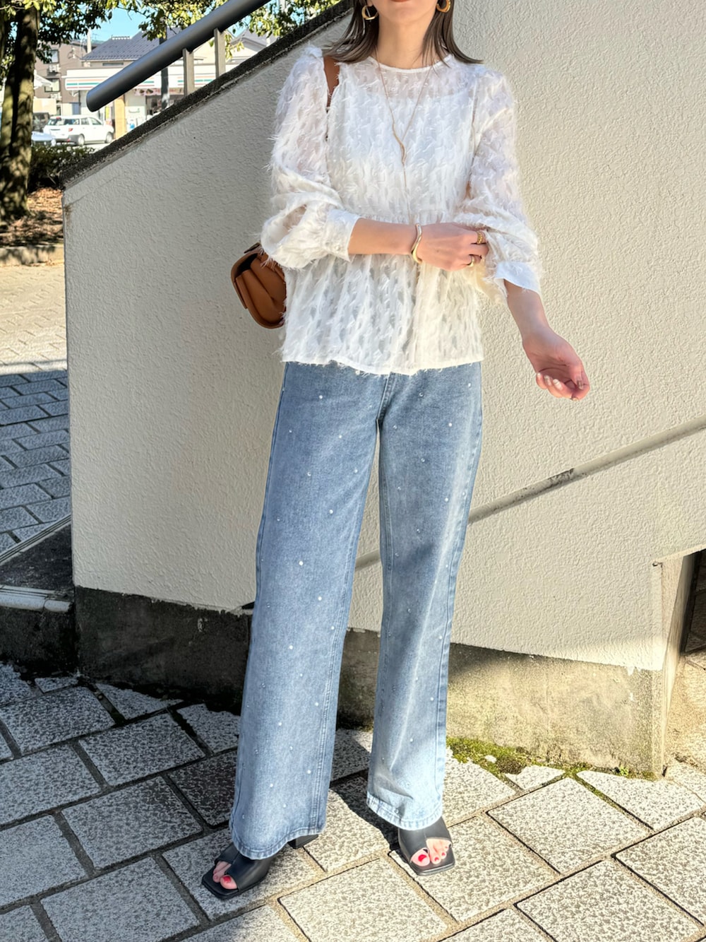 ホワイト系のシャツ/ブラウス、ブルー系のデニムパンツ、ベージュ系のショルダーバッグを着用したレディースの春コーディネートの2枚目の写真