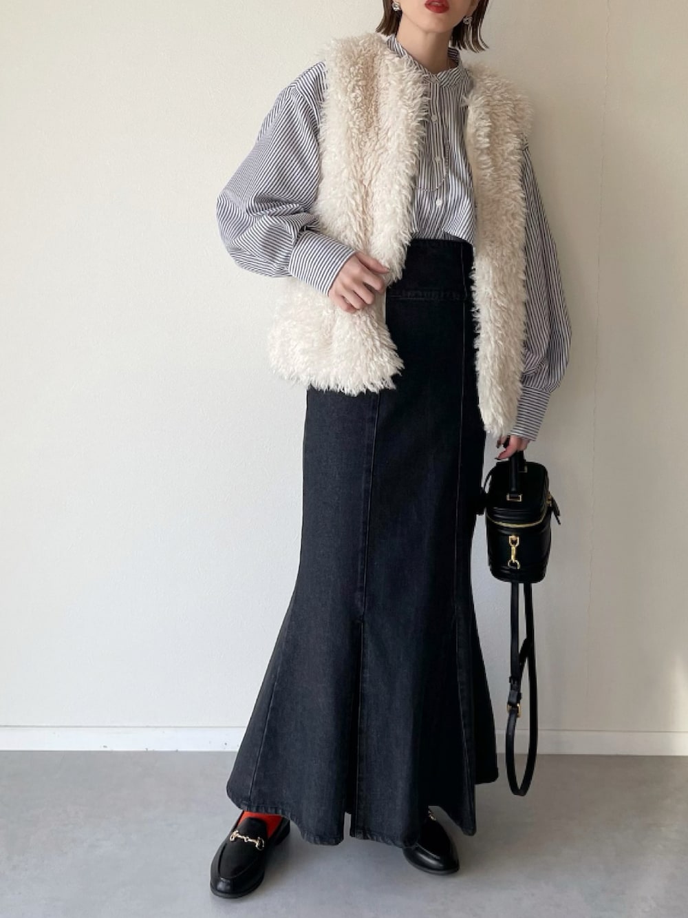 ブラック系のシャツ/ブラウス、ホワイト系のベスト、ブラック系のその他シューズを着用したレディースの冬コーディネートの2枚目の写真