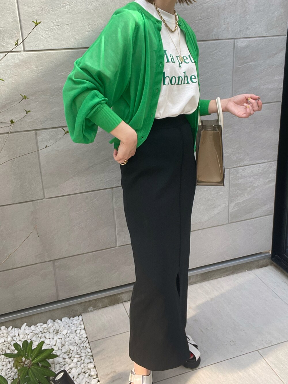 ブラック系のスカート、ホワイト系のサンダル、ホワイト系のショルダーバッグを着用したレディースの春コーディネートの2枚目の写真