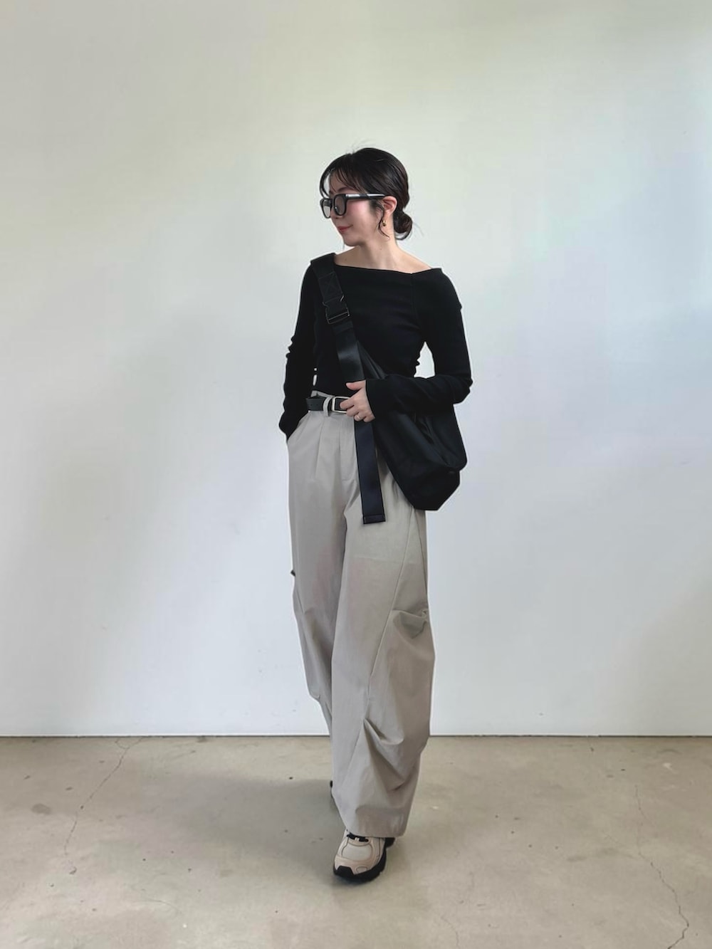 ブラック系のTシャツ/カットソー、グレー系のその他パンツ、ブラック系のショルダーバッグを着用したレディースの春コーディネートの4枚目の写真