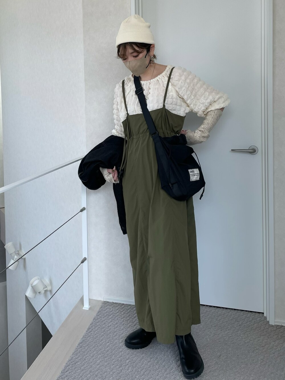 グリーン系のワンピース、ブラック系のショルダーバッグ、ホワイト系のTシャツ/カットソーを着用したレディースの春コーディネートの2枚目の写真