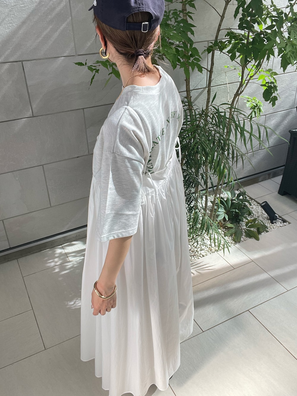 ホワイト系のワンピース、ブラック系のサンダルを着用したレディースの春コーディネートの4枚目の写真