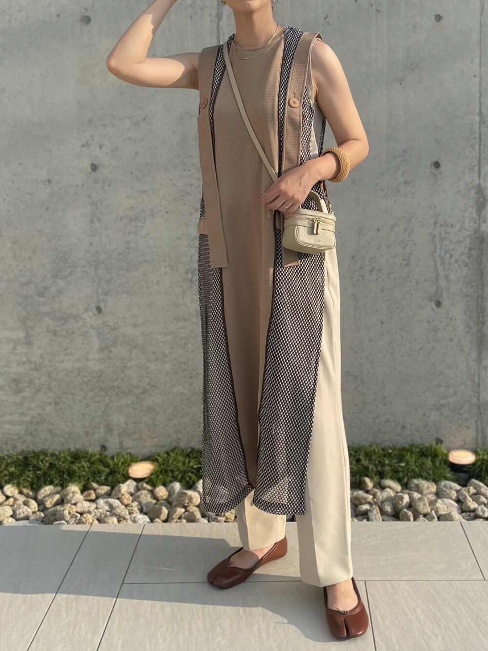 ベージュ系のワンピース、ベージュ系のショルダーバッグ、ブラウン系のパンプスを着用したレディースの夏コーディネートの2枚目の写真