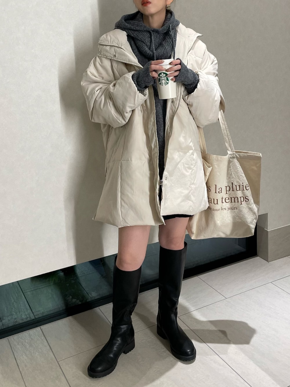 ホワイト系のダウンジャケット/コート、グレー系のニット/セーター、ブラック系のその他パンツを着用したレディースの秋コーディネートの2枚目の写真
