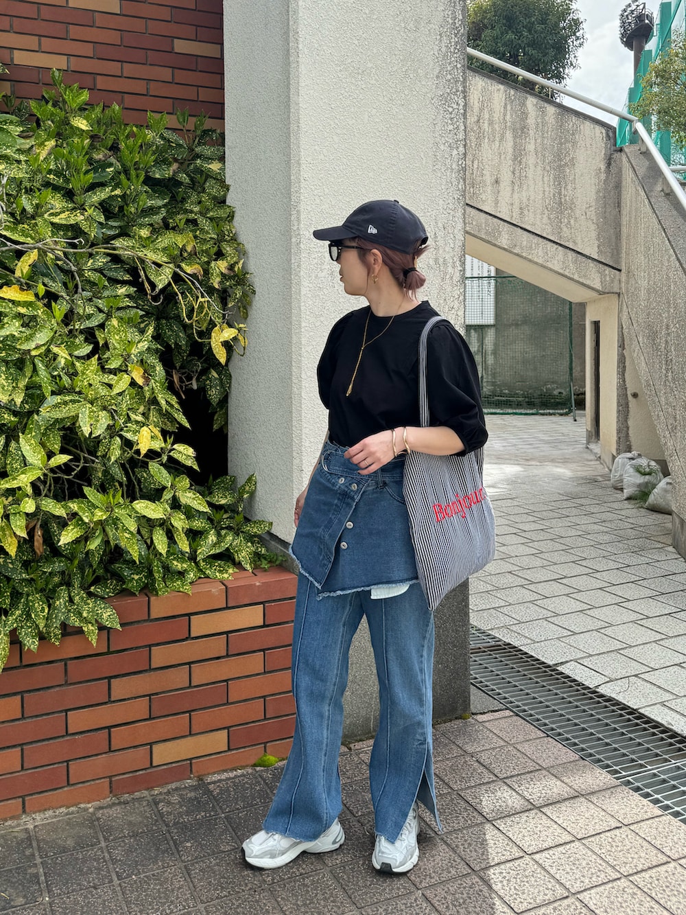 ブラック系のシャツ/ブラウス、ブラック系のトートバッグ、ブルー系のデニムパンツを着用したレディースの春コーディネートの2枚目の写真