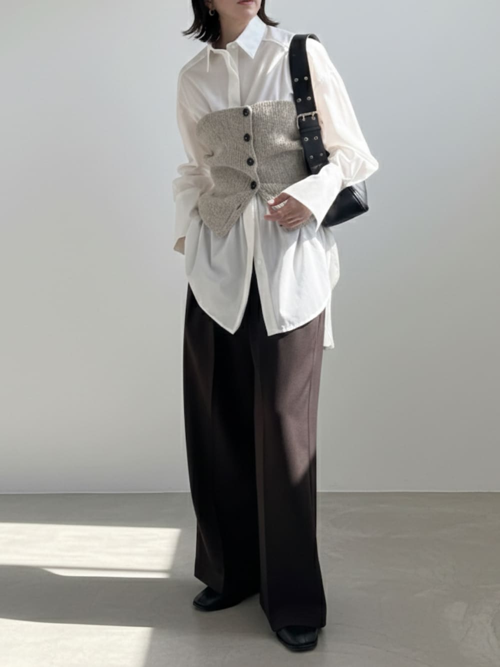 ブラウン系のその他パンツ、ブラック系のハンドバッグ、ベージュ系のベストを着用したレディースの冬コーディネートの2枚目の写真