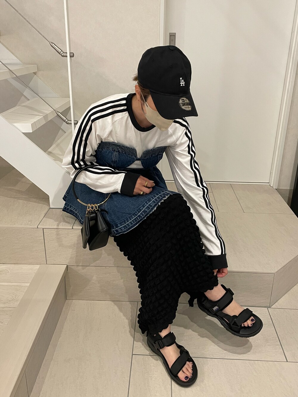 ブラック系のサンダル、ブルー系のTシャツ/カットソー、ブラック系のスカートを着用したレディースの春コーディネートの2枚目の写真