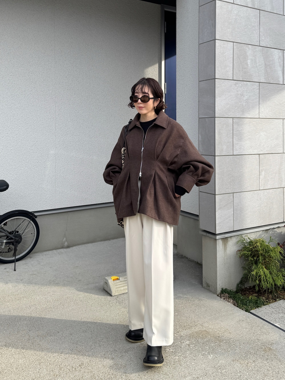 ブラウン系のブルゾン、ブラック系のTシャツ/カットソー、ホワイト系のその他パンツを着用したレディースの冬コーディネートの2枚目の写真