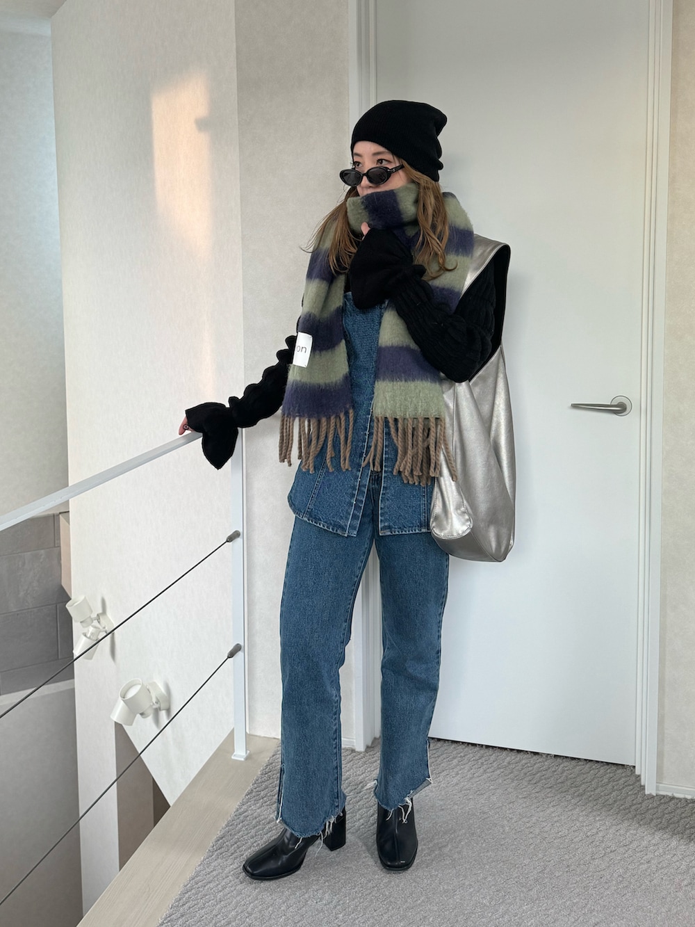 ブルー系のデニムパンツ、シルバー系のトートバッグ、ブルー系のデニムパンツを着用したレディースの冬コーディネートの2枚目の写真