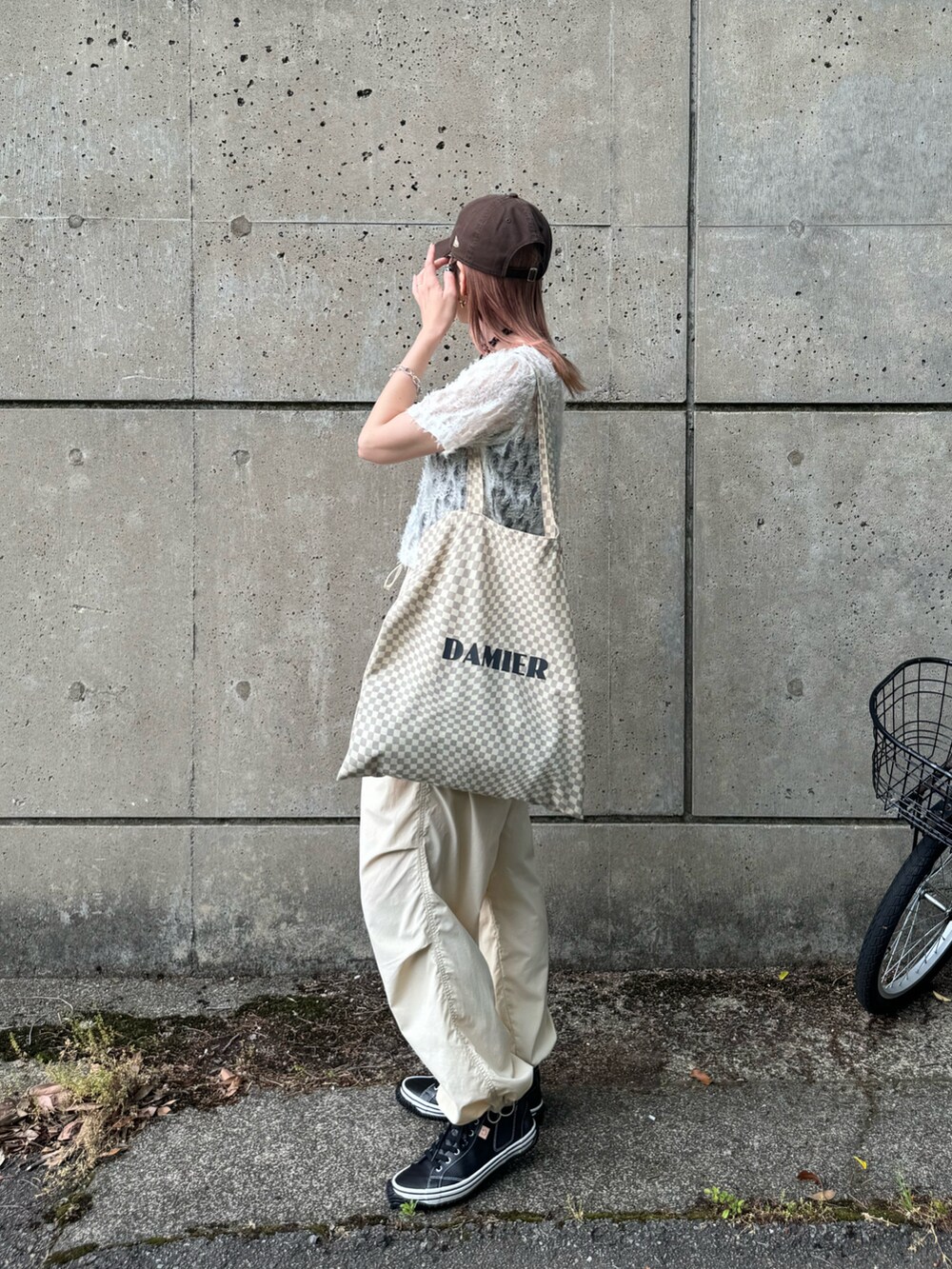 ブラック系のスニーカー、ホワイト系のTシャツ/カットソー、ベージュ系のトートバッグを着用したレディースの春コーディネートの4枚目の写真