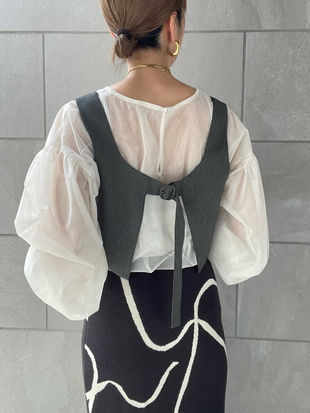 グレー系のスカート、ホワイト系のシャツ/ブラウス、ブラック系のハンドバッグを着用したレディースの夏コーディネートの4枚目の写真