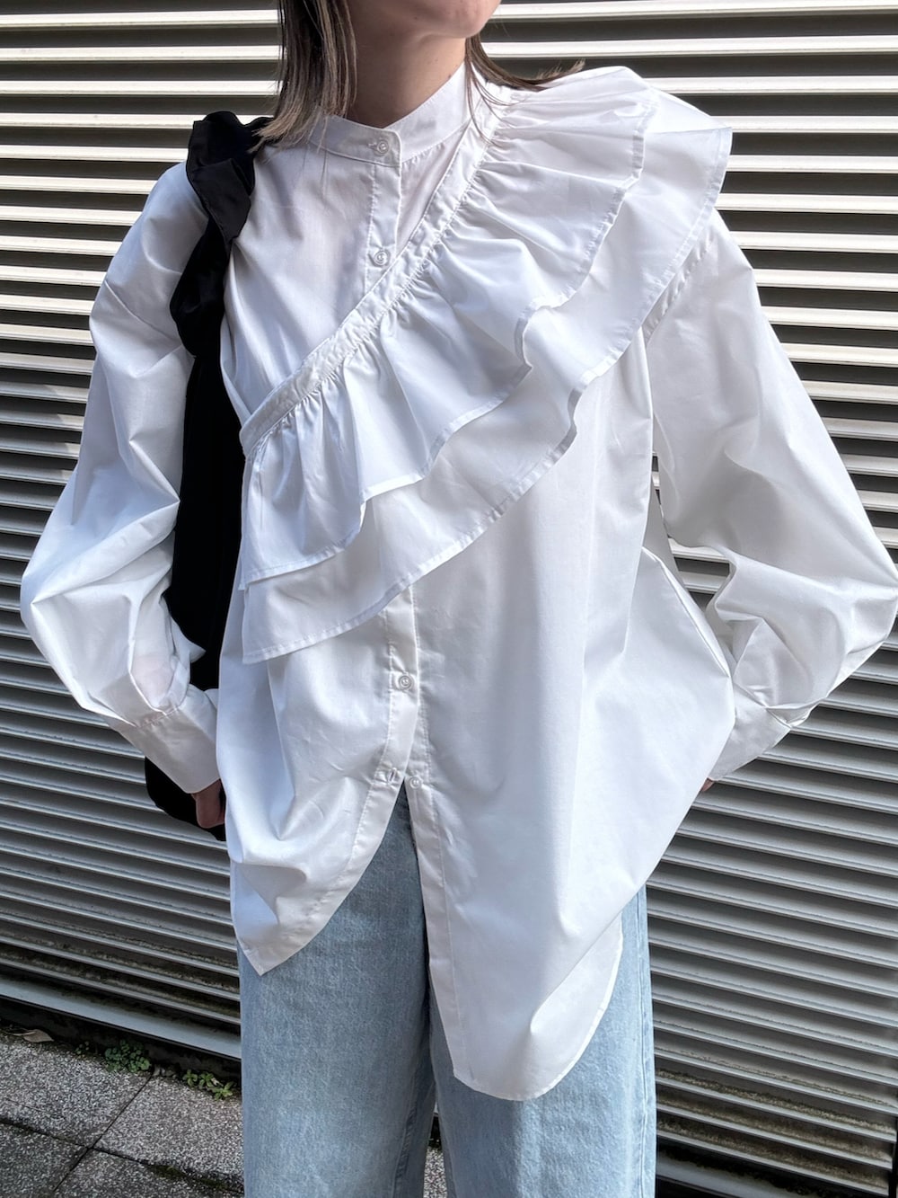 ホワイト系のシャツ/ブラウス、シルバー系のパンプス、ブルー系のデニムパンツを着用したレディースの冬コーディネートの5枚目の写真