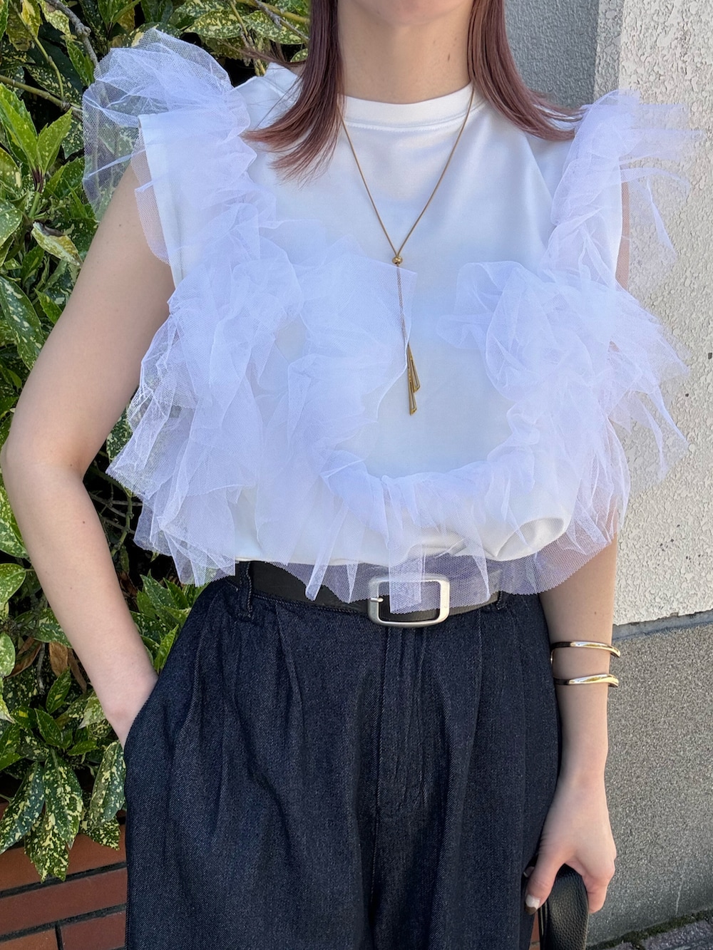 ブルー系のデニムパンツ、ホワイト系のタンクトップ、ブラック系のハンドバッグを着用したレディースの春コーディネートの5枚目の写真