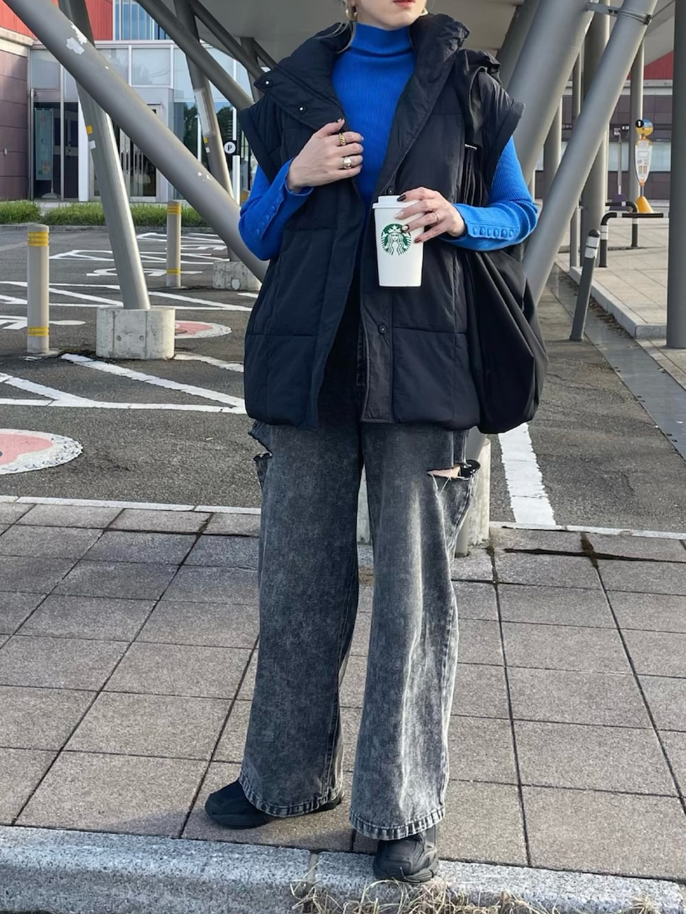 ブルー系のニット/セーター、ブラック系のデニムパンツ、ブラック系のスニーカーを着用したレディースの秋コーディネートの4枚目の写真