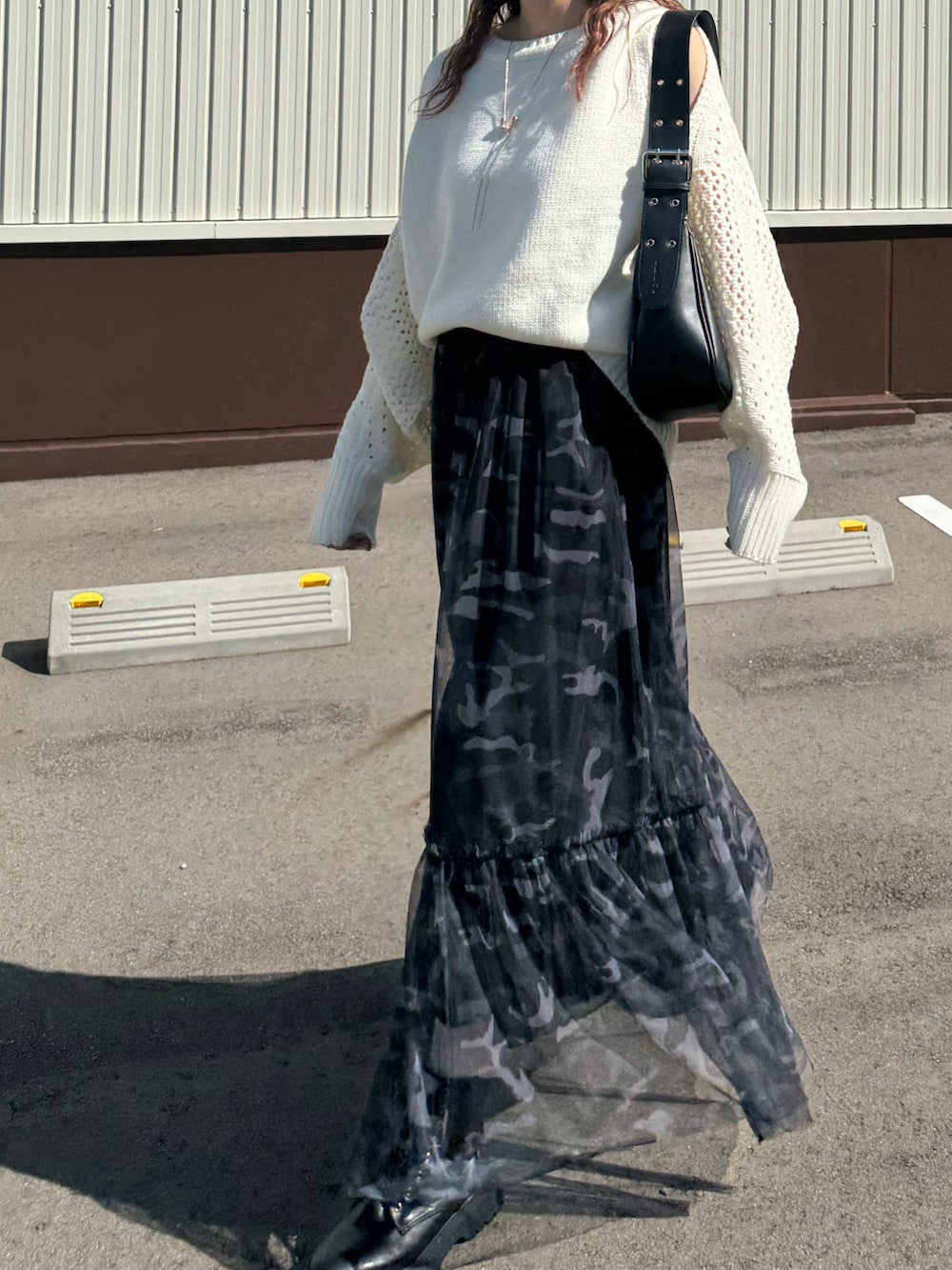 ホワイト系のニット/セーター、ブラック系のハンドバッグ、ブラック系のキャップを着用したレディースの秋コーディネートの3枚目の写真