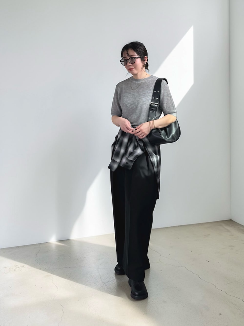 ブラック系のシャツ/ブラウス、グレー系のニット/セーター、ブラック系のその他パンツを着用したレディースの春コーディネートの2枚目の写真